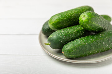 Cucumber on wooden background. Slice of cucumber on background. Fresh organic green cucumbers gherkin. Vegan. Salad ingredient. Farm vegetables. Cut vegetables with knife. Space for text. Copy space