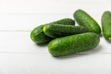 Cucumber on wooden background. Slice of cucumber on background. Fresh organic green cucumbers gherkin. Vegan. Salad ingredient. Farm vegetables. Cut vegetables with knife. Space for text. Copy space