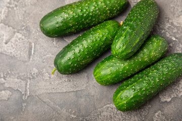 Cucumber on wooden background. Slice of cucumber on background. Fresh organic green cucumbers gherkin. Vegan. Salad ingredient. Farm vegetables. Cut vegetables with knife. Space for text. Copy space
