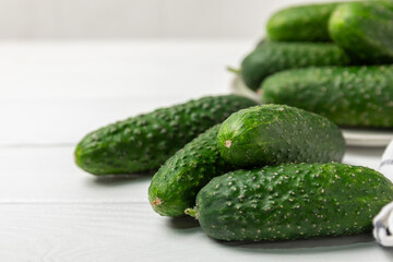Cucumber on wooden background. Slice of cucumber on background. Fresh organic green cucumbers gherkin. Vegan. Salad ingredient. Farm vegetables. Cut vegetables with knife. Space for text. Copy space
