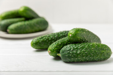 Cucumber on wooden background. Slice of cucumber on background. Fresh organic green cucumbers gherkin. Vegan. Salad ingredient. Farm vegetables. Cut vegetables with knife. Space for text. Copy space
