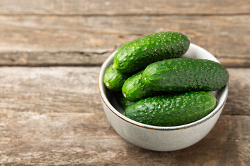Cucumber on wooden background. Slice of cucumber on background. Fresh organic green cucumbers gherkin. Vegan. Salad ingredient. Farm vegetables. Cut vegetables with knife. Space for text. Copy space