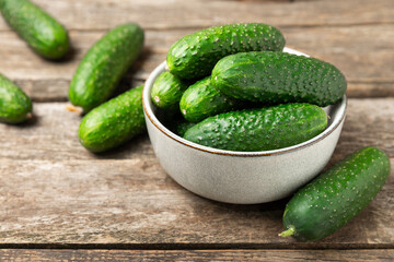 Cucumber on wooden background. Slice of cucumber on background. Fresh organic green cucumbers gherkin. Vegan. Salad ingredient. Farm vegetables. Cut vegetables with knife. Space for text. Copy space