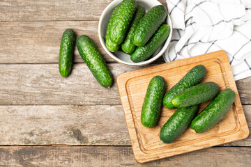 Cucumber on wooden background. Slice of cucumber on background. Fresh organic green cucumbers gherkin. Vegan. Salad ingredient. Farm vegetables. Cut vegetables with knife. Space for text. Copy space