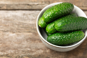 Cucumber on wooden background. Slice of cucumber on background. Fresh organic green cucumbers gherkin. Vegan. Salad ingredient. Farm vegetables. Cut vegetables with knife. Space for text. Copy space
