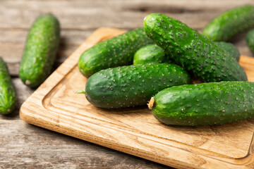 Cucumber on wooden background. Slice of cucumber on background. Fresh organic green cucumbers gherkin. Vegan. Salad ingredient. Farm vegetables. Cut vegetables with knife. Space for text. Copy space