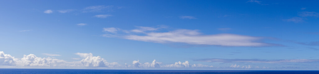 Panoramic Seascape With Clouds Over A Vast Ocean Under A Vibrant Blue Sky