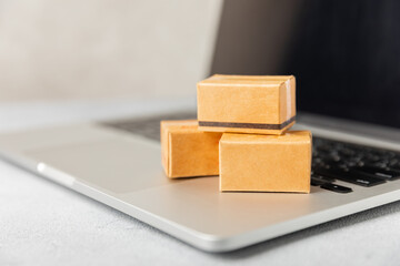 Online shopping concept.Cardboard box and shopping bags in a trolley on a bright colored background. Shopping basket. Online shopping using a laptop, tablet, phone and credit card. Home delivery.