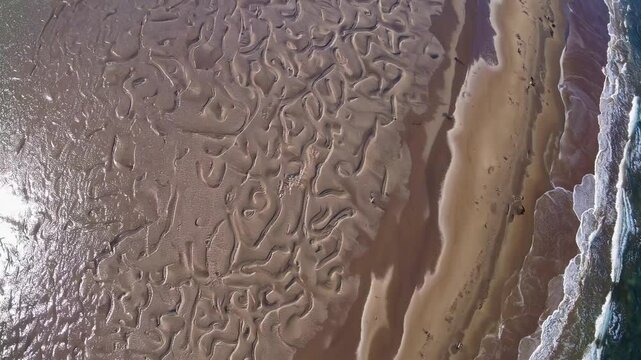Intricate patterns etched on the shoreline, a dance between sea and sand. Aerial view of the coast, featuring unique textures and natural beauty.