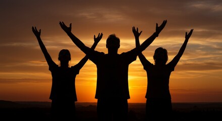 Fototapeta premium Silhouettes of people raising arms to the sky during majestic sunset glow