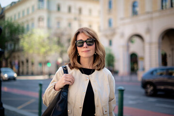 Fototapeta premium Blond haired woman standing at the city street