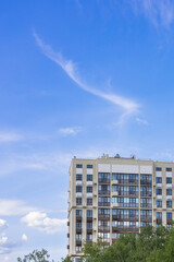 An apartment building against a blue sky. A modern residential building.