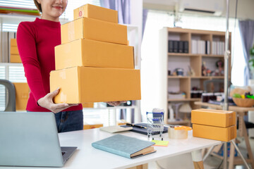 businesswoman in red shirt standing holding parcel box ready to deliver to customer who ordered...