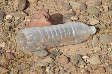 A single empty plastic bottle lying on the ground, Environmental pollution