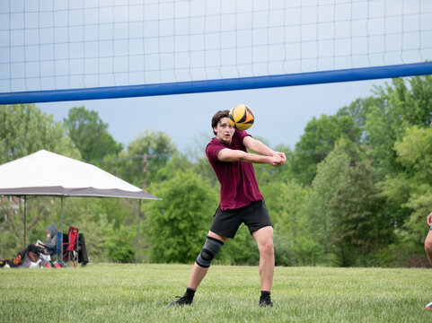 Focused Volleyball player passing the ball during a grass doubles match