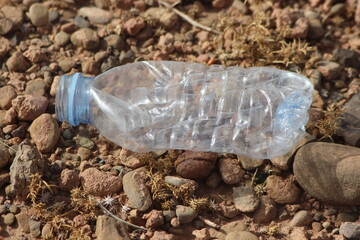 A single empty plastic bottle lying on the ground, Environmental pollution