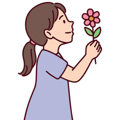 Young girl closes her eyes and smells a flower with a calm and peaceful expression. She holds the pink blossom gently, representing a serene moment of connection with nature and mindfulness