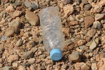 A single empty plastic bottle lying on the ground, Environmental pollution