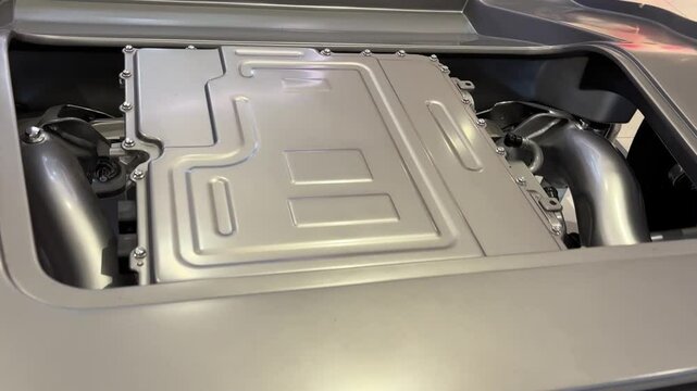 Rear section of electric vehicle chassis featuring powertrain components like electric motor, transmission, inverter, suspension and subframe design.