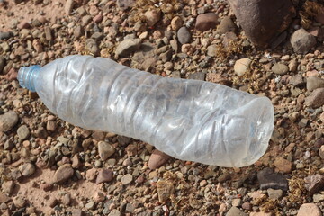 A single empty plastic bottle lying on the ground, Environmental pollution