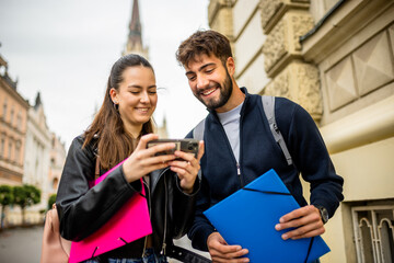 Two Students Studying Literature Together on a Smartphone While Walking