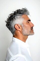 Obraz premium Pure white solid background. Elegant men's slicked back haircut - midlife arabian man with curly hair. A chic and vibrant male with effortless elegance. Creative of style for aging men.