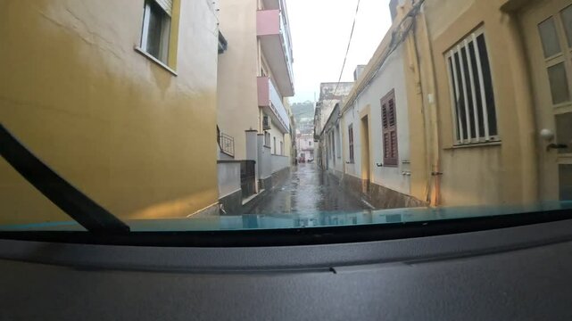Driving in Sicily through a narrow alley called in local dialect "vinedda"