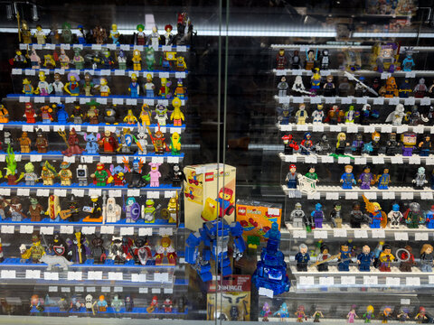 Moscow, Russia, April 25, 2025: Assorted Lego mini figures and rare collectible sets, including vintage Lego System boxes, displayed in glass showcase at toy collector stall in local market