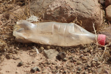 A single empty plastic bottle lying on the ground, Environmental pollution