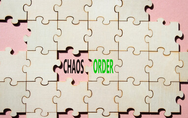 Fototapeta premium Chaos or Order symbol. Concept word Chaos or Order on wooden puzzle. Beautiful pink background. Business and Chaos or Order concept. Copy space