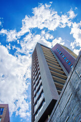 Modern high-rise residential building in the Netherlands, Europe under a blue sky with clouds on a sunny day, urban architecture concept