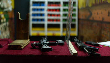 Display of various firearms on a counter in an indoor setting showcasing weapons for sale