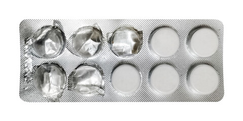 A direct overhead shot of a blister pack, prominently displaying four white, round pills on one side and six empty, pressed-out compartments on the other. The clear distinction between full and empty 