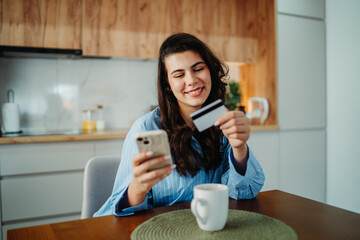 Young caucasian woman shop or pay online using credit card and smartphone