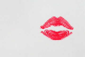 A bright lipstick print on a light surface. Space for text.