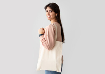 Environmental Protection. Portrait of smiling woman standing with blank canvas tote bag, free copy...