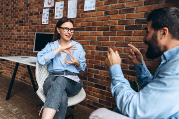 Colleagues using sign language discussing about work in the office