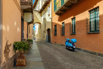 Scooter on the cobblestone street in old town of Alba, Italy.