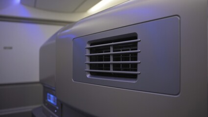 Fototapeta premium Luxurious private jet cabin air conditioning vent elegantly crafted from brushed steel softly illuminated by ambient LED lights