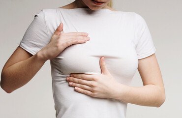 Breast screening. Young woman examining her breasts, cancer prevention, closeup