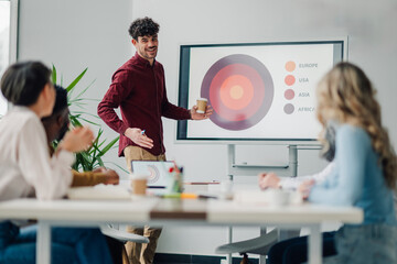 Marketing specialist leading presentation on global market trends to colleagues