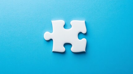 Obraz premium A single, white puzzle piece rests on a vibrant blue background.
