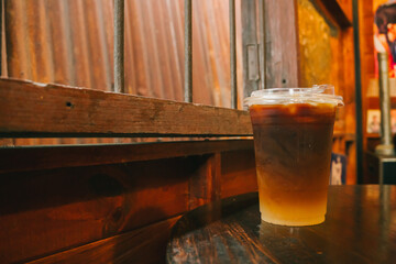 Refreshing Iced Coffee Beverage on a Wooden Table in a Rustic Cafe Setting with Warm Tones and Cozy Atmosphere