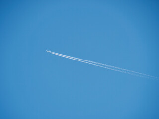 Airplane Leaving Contrails Against Clear Blue Sky