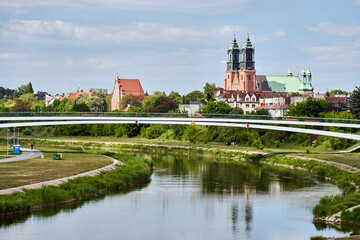 Fototapeta premium modern footbridge and towers of the historic cathedral over the Warta River in Poznan