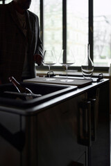 Clean wine glasses and decanter are on the table of a special wine cabinet, stylish table setting,...