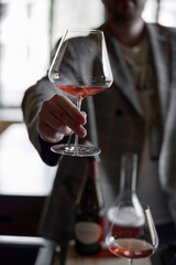 Champagne tasting in restaurant, A man holds in his hand a beautiful elegant glass with rose sparkling wine