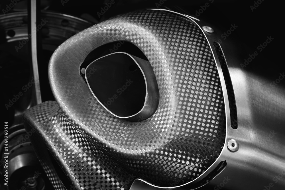 Poster dark close-up of a black and silver motorcycle exhaust pipe with mesh pattern. concept of sleekness 