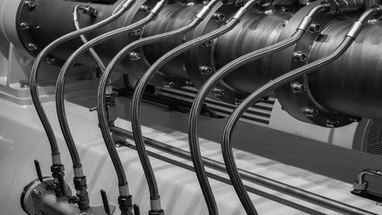 A series of pipes are connected to a large machine. The pipes are made of metal and are connected to each other. The machine is large and has a metallic appearance