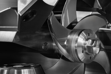 A close up of a machine with a silver blade. The blade is sharp and has a lot of detail. The...